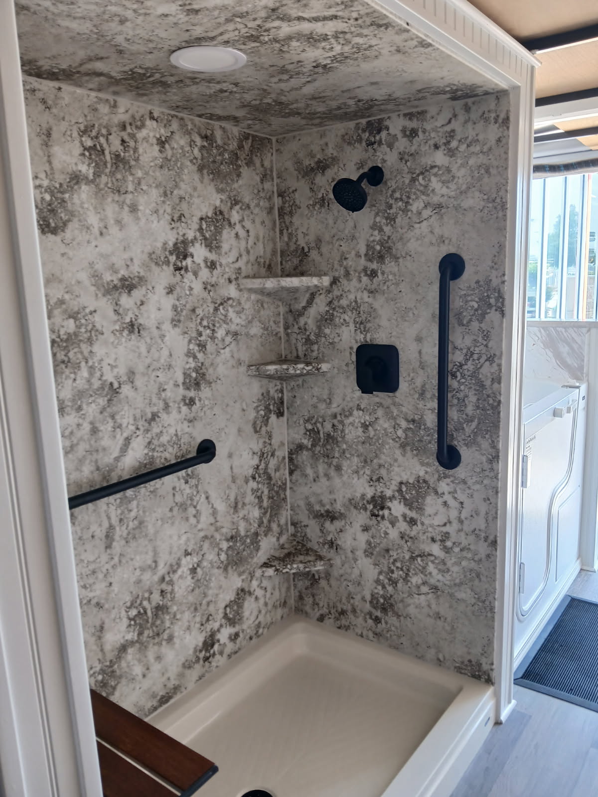Walk-in shower with stone surround and grab bars in a Northeast Missouri home